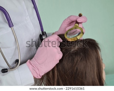 Trichologist examines condition of child girl hair. Lice nits and dandruff in children