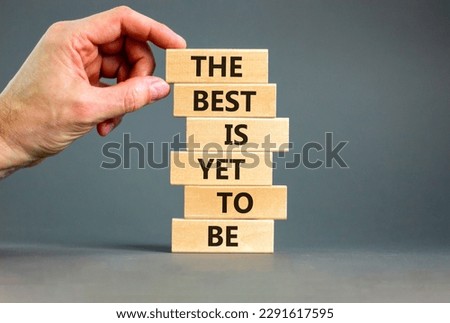 The best is yet to be symbol. Wooden blocks with concept words The best is yet to be. Beautiful grey background, copy space. Businessman hand. Business, the best is yet to be concept.