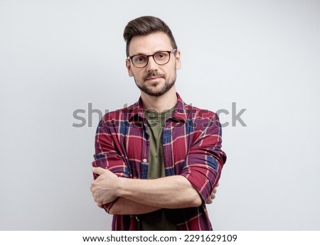 Portrait of a handsome man wearing glasses on grey background. Looking at camera