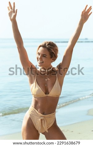 Carefree beautiful woman wearing bikini and necklace with seashells relaxing on the beach during her vacation