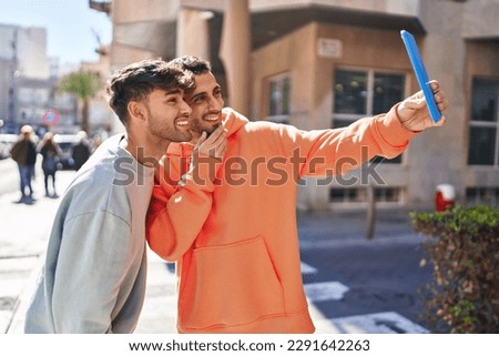 Two man couple make selfie by touchpad at street