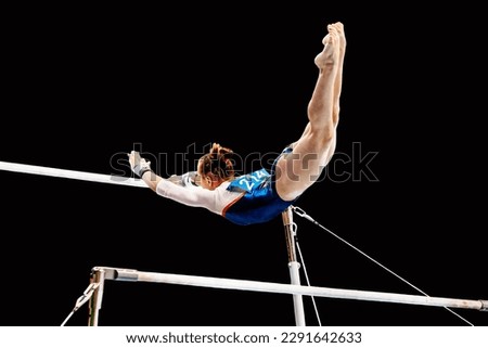 female gymnast exercise on uneven bars in artistic gymnastics, flight element from low bar to high bar, black background