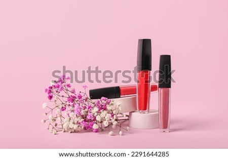 Decorative plaster podium, lip gloss and gypsophila flowers on pink background Royalty-Free Stock Photo #2291644285