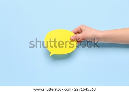 Woman holding blank speech bubble on blue background