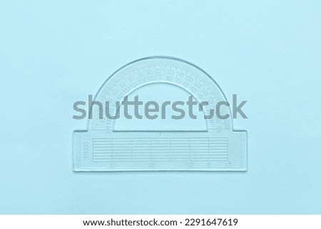 Transparent plastic protractor on blue background
