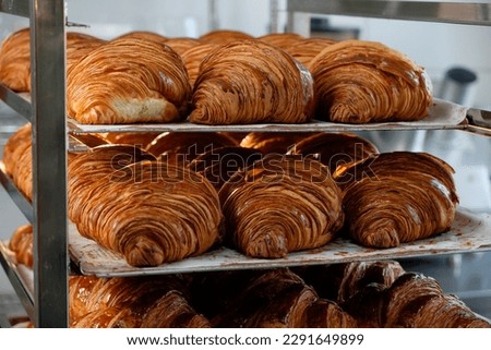 Close up shoot of freshly baked croissants are in tray after leaving the oven for customers on breakfast in a commercial kitchen