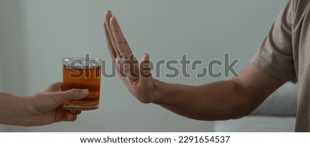 man refuses say no and avoid to drink an alcohol whiskey , stopping hand sign male, alcoholism treatment, alcohol addiction, quit booze, Stop Drinking Alcohol. Refuse Glass liquor, unhealthy, reject Royalty-Free Stock Photo #2291654537