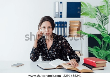 female office worker in the office with book at the desk in the office