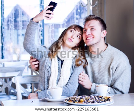 Holidays, vacation and happiness concept - young couple, friends taking picture with smartphone 