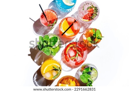 Summer cocktails drinks set. Assortment of multicolored strong and low alcoholic beverages for cocktail party. White background, hard light, shadows pattern, top view Royalty-Free Stock Photo #2291662831