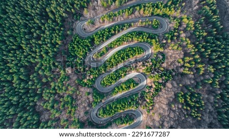 Aerial photography of a winding road in the mountains with serpentines and curves. Photography was shot from a drone at a higher altitude. Royalty-Free Stock Photo #2291677287