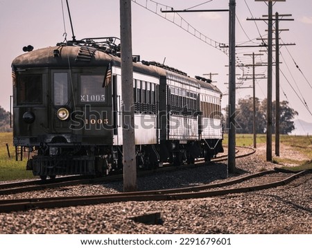 A vintage electric train runs along the former mainline of the Sacramento Northern Railway. Royalty-Free Stock Photo #2291679601