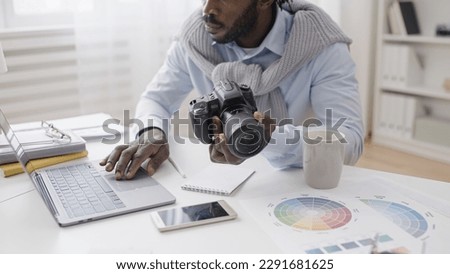 A concentrated photographer is adjusting the camera settings according to the online tutorial