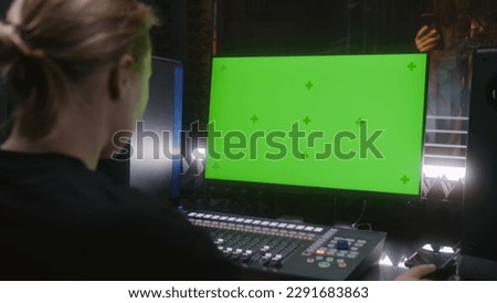 Male singer records song in soundproof room. Female audio engineer, producer uses control mixing surface. Computer screen showing DAW software with sound tracks. Sound recording studio. Green screen.