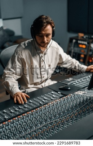 Sound engineer working in home music studio with monitors and equalizer screen mixing and mastering tracks