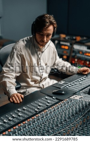 Sound engineer working in home music studio with monitors and equalizer screen mixing and mastering tracks