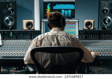 Sound engineer working in music studio with monitors and equalizer screen mixing and mastering tracks Royalty-Free Stock Photo #2291689817