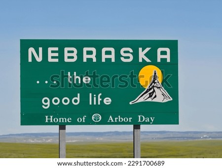 A road sign with the text Nebraska, the good life, Home of Arbor Day 