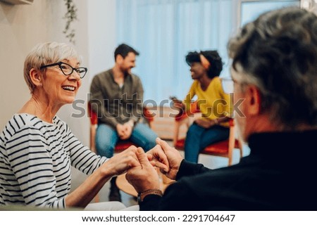 Portrait of a couple of senior people holding hands while participating in group therapy session. Sharing problems, telling stories during psychological rehab session. Copy space. Royalty-Free Stock Photo #2291704647