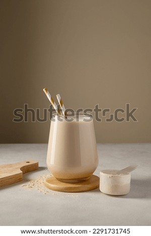 Healthy chocolate protein shake drink with straw, and protein powder. Royalty-Free Stock Photo #2291731745