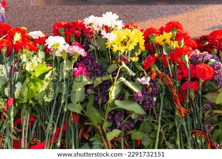 Victory Day, 9 May holiday concept. ribbon of St.George and flowers, natural spring background. traditional symbol of Victory Day 1945. memory of war 1941-1945.