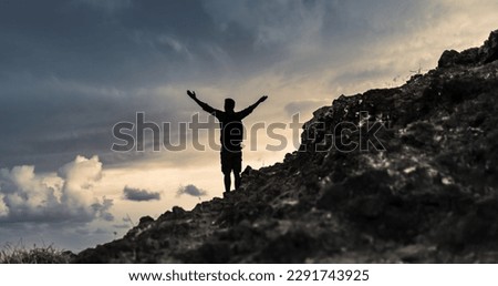 Hiker with arms up standing on the top of the mountain - Successful man enjoying triumph - Sport and success concept	