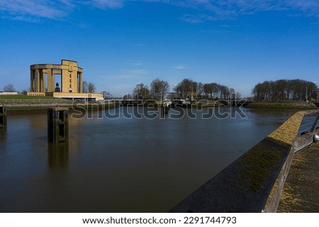 Overview at the Westfront located at city Nieuwpoort at the belgium coast.  River de ijzer with the Koning Albert I monument and a blue sky.  Belgium coast toerism picture.  With the
water dam.