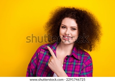 Portrait of gorgeous pretty youngster woman directing finger empty space announce coming soon season discount isolated on yellow color background