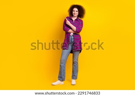 Full length photo of sweet shiny lady wear checkered jacket pointing finger empty space isolated yellow color background