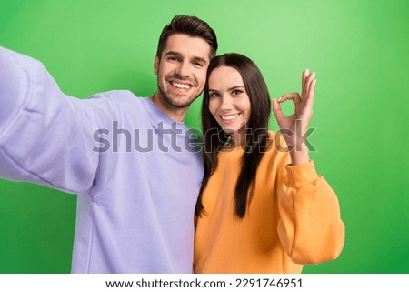 Photo of cheerful attractive lady handsome guy make selfie demonstrate okey symbol isolated on green color background