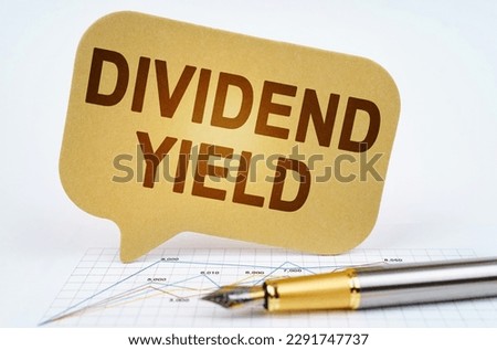 Business concept. On the business diagram is a pen and a sign with the inscription - DIVIDEND YIELD