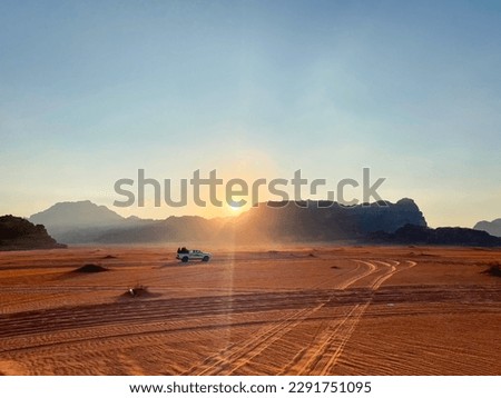 Safari in Wadi Rum desert, Jordan, Middle East. Tourists in the car ride on off-road on sand among the beautiful rocks at sunset. Royalty-Free Stock Photo #2291751095