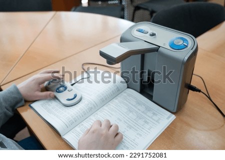 A visually impaired man uses a scanning and reading machine. Royalty-Free Stock Photo #2291752081