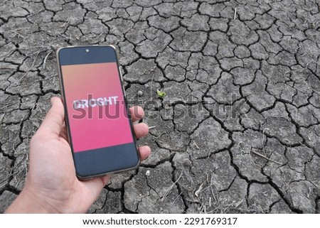 A person is holding a phone with the word drought on the screen. Drought and climate crisis