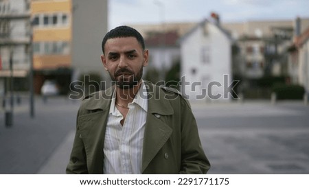 Portrait of one MIddle Eastern man standing outside in city street with natural expression Royalty-Free Stock Photo #2291771175