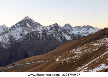 Winter mountains with snow and blue sky in nice sun day. Ski resort and sport concept. Caucasus Mountains, region Dombay. View from the top of Musa Achitara, copy space, moc up Royalty-Free Stock Photo #2291790597