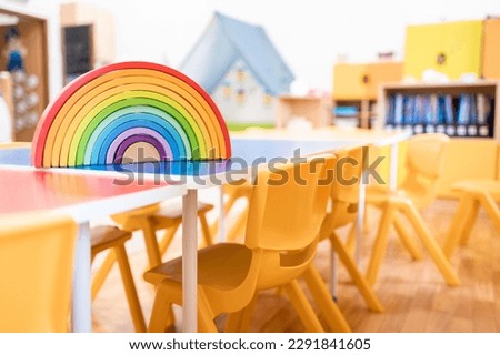 Colorful kindergarten class without childs ,school education desk, chair, toy and decoration on background wall. Childhood.