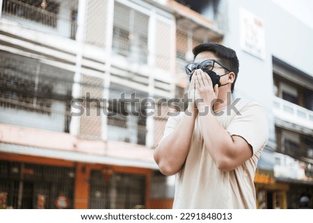 Asian man wearing face mask protect filter against air pollution (PM2.5) and Car pollution on street. Anti smog and virus. Air pollution caused health problem. Environmental pollution concept. Royalty-Free Stock Photo #2291848013