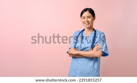 Portrait of young attractive doctor standing and have her arms crossed against pink isolated background.  Royalty-Free Stock Photo #2291855257