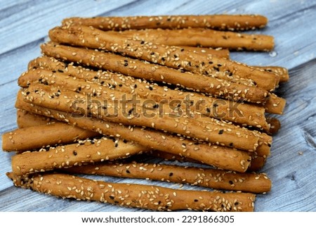 Pile of Breadsticks, also known as grissini, grissino or dipping sticks, pencil-sized sticks of crisp, dry baked bread salty with cumin and covered with sesame seeds and black seeds or Habat Al Baraka Royalty-Free Stock Photo #2291866305