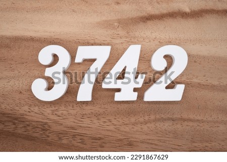 White number 3742 on a brown and light brown wooden background.