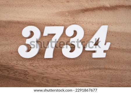 White number 3734 on a brown and light brown wooden background.