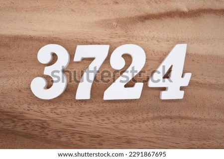 White number 3724 on a brown and light brown wooden background.