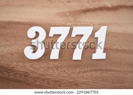 White number 3771 on a brown and light brown wooden background.