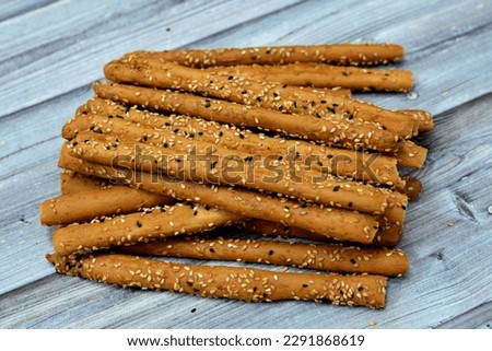 Pile of Breadsticks, also known as grissini, grissino or dipping sticks, pencil-sized sticks of crisp, dry baked bread salty with cumin and covered with sesame seeds and black seeds or Habat Al Baraka Royalty-Free Stock Photo #2291868619