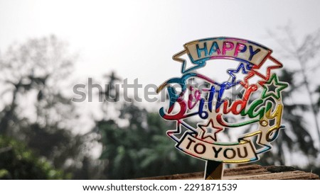Happy Birthday Poster in a blurry background at day time