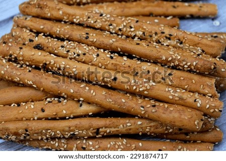 Pile of Breadsticks, also known as grissini, grissino or dipping sticks, pencil-sized sticks of crisp, dry baked bread salty with cumin and covered with sesame seeds and black seeds or Habat Al Baraka Royalty-Free Stock Photo #2291874717