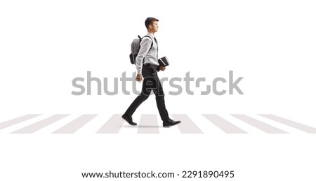 Male student with a backpack in a shirt and tie holding books and walking at a pedestrian zebra crossing isolated on white background

