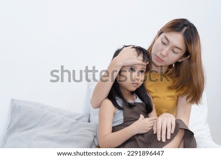Asian mother hug her sick daughter on the bed with worry on her face Royalty-Free Stock Photo #2291896447