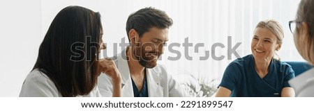 Group of doctors sitting at meeting table in conference room during medical seminar